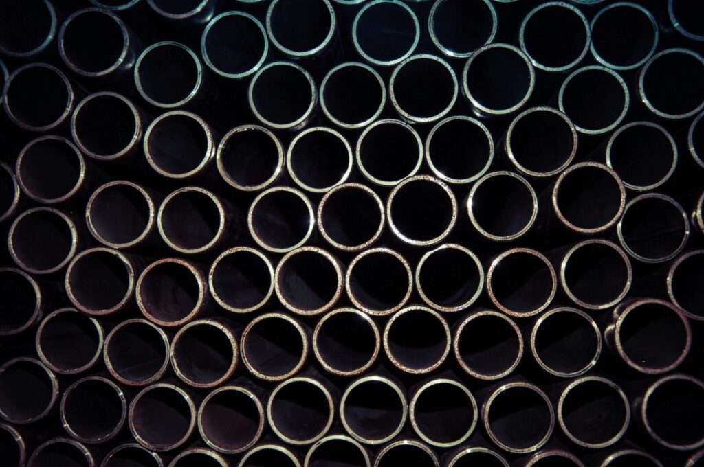 Stacked steel pipes arranged in an industrial warehouse