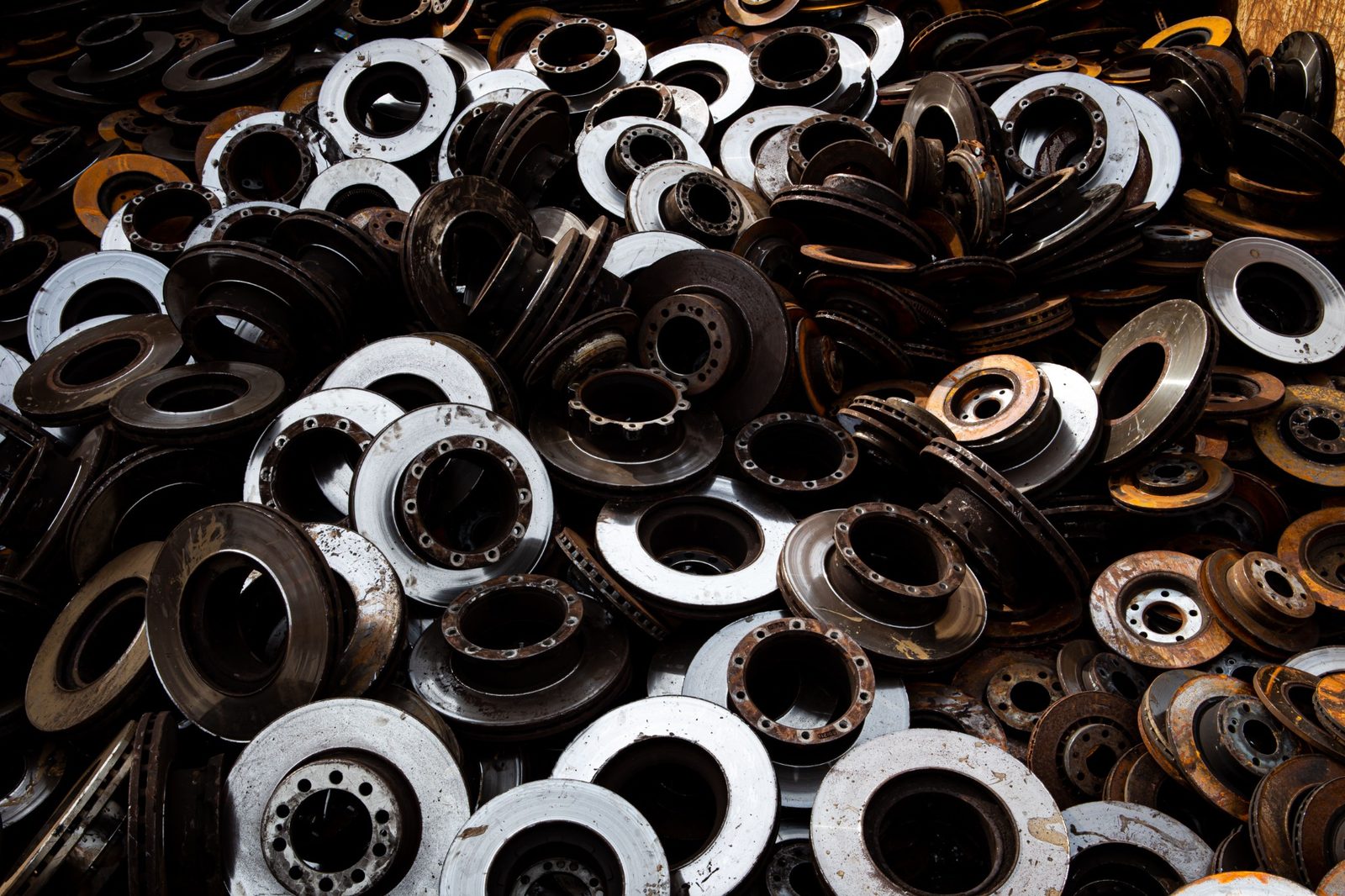 Pile of used automotive brake discs and metal rotors ready for recycling